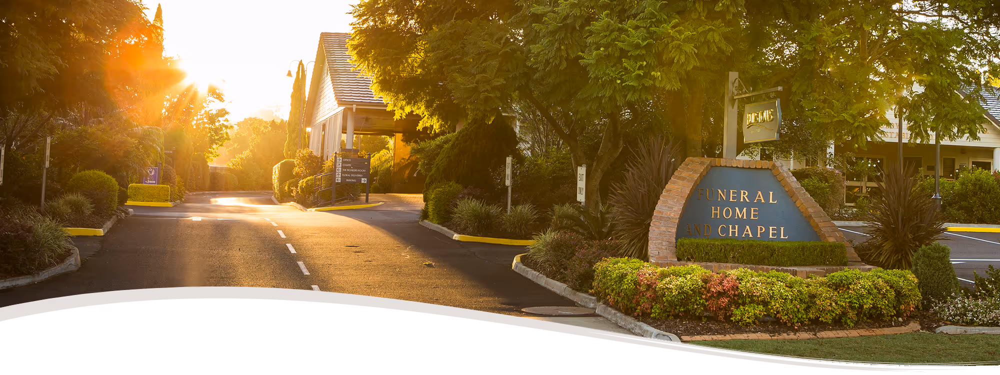 A long-distance view of a Burstows funeral home and chapel at sunset.