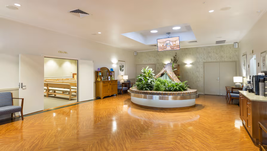 Funeral home lobby with plants and chapel entrance.