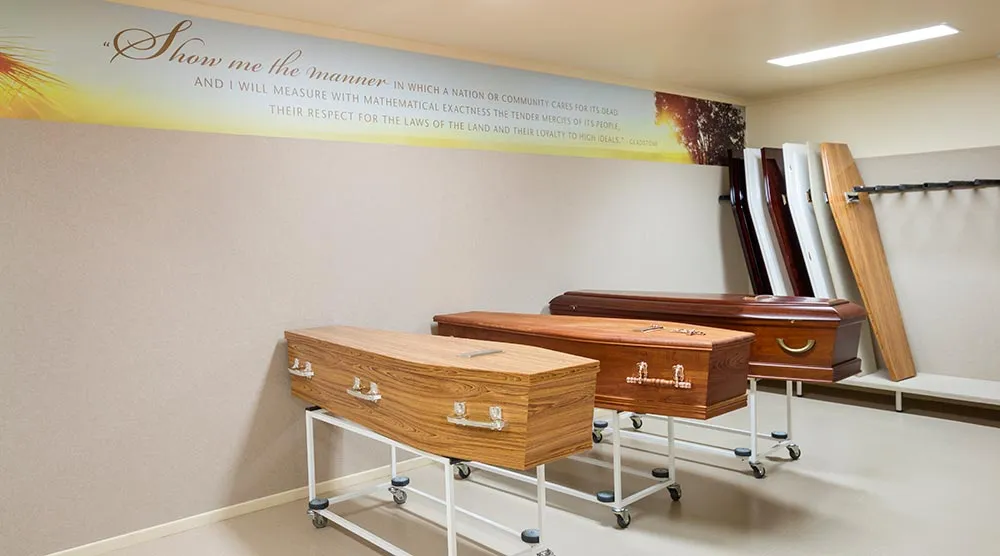 Three coffins in a funeral home display room.