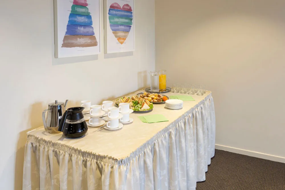 Buffet table with white cloth and serving dishes.