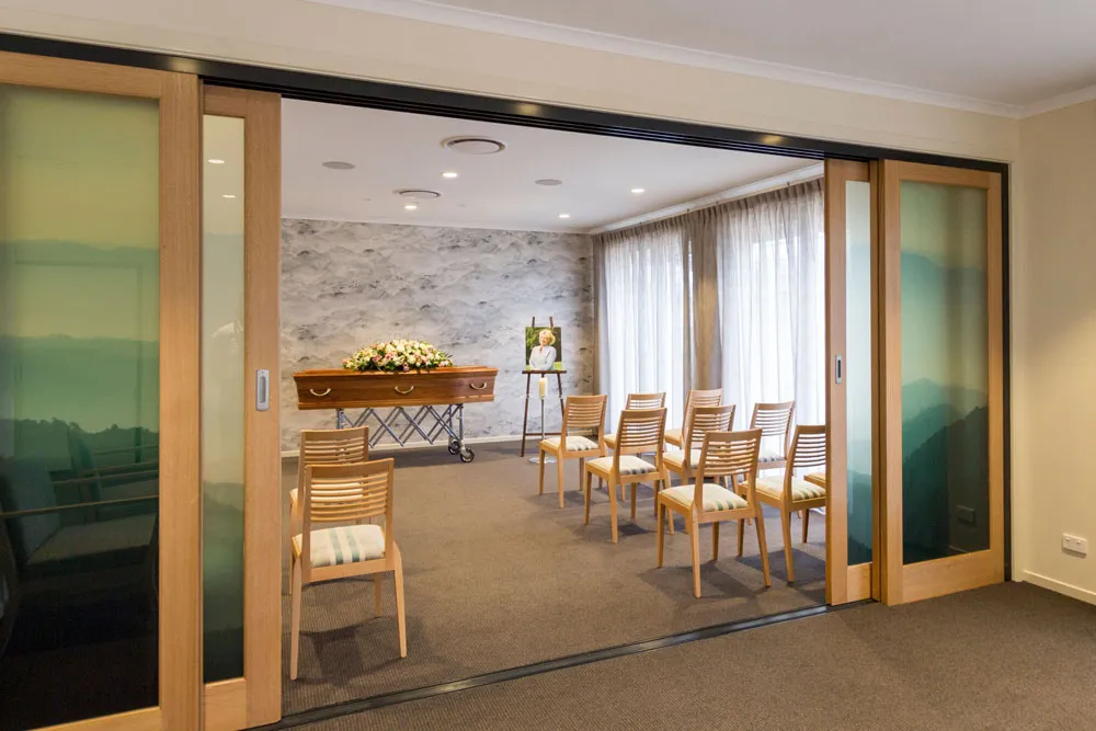 Room with sliding glass doors, set for an event.