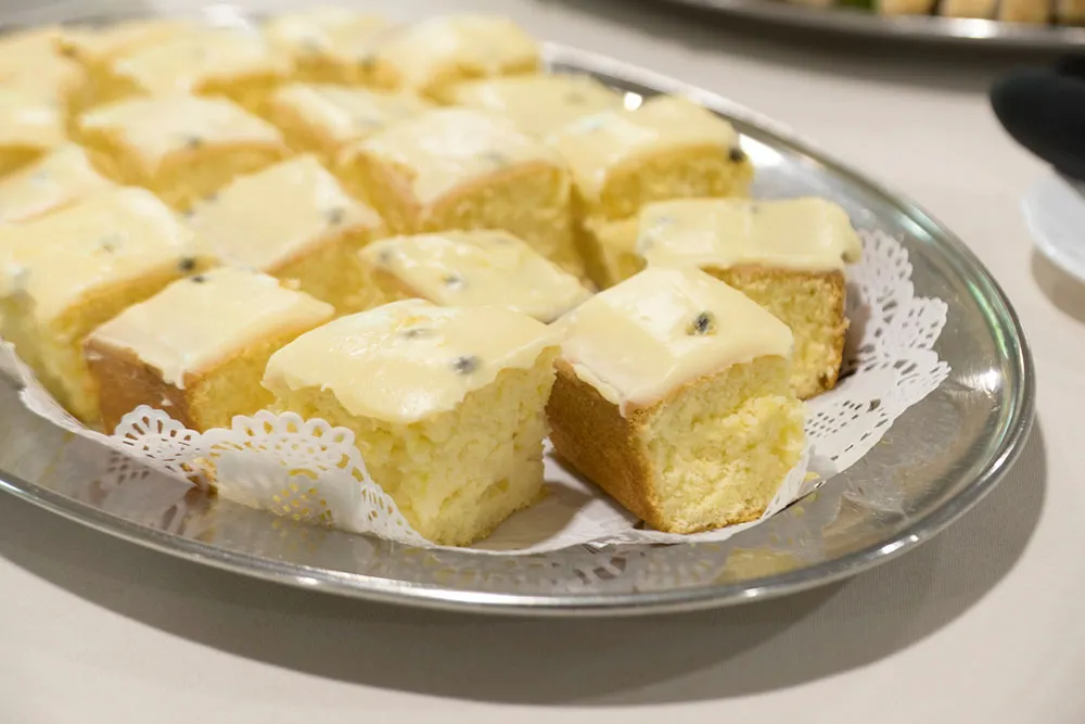 Tray of small, square dessert pastries.