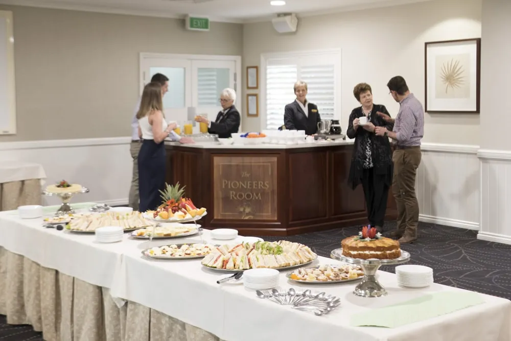 People gathered around a buffet table, serving themselves.
