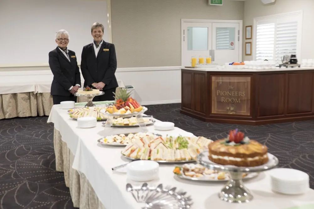 Buffet table laden with food and a server.