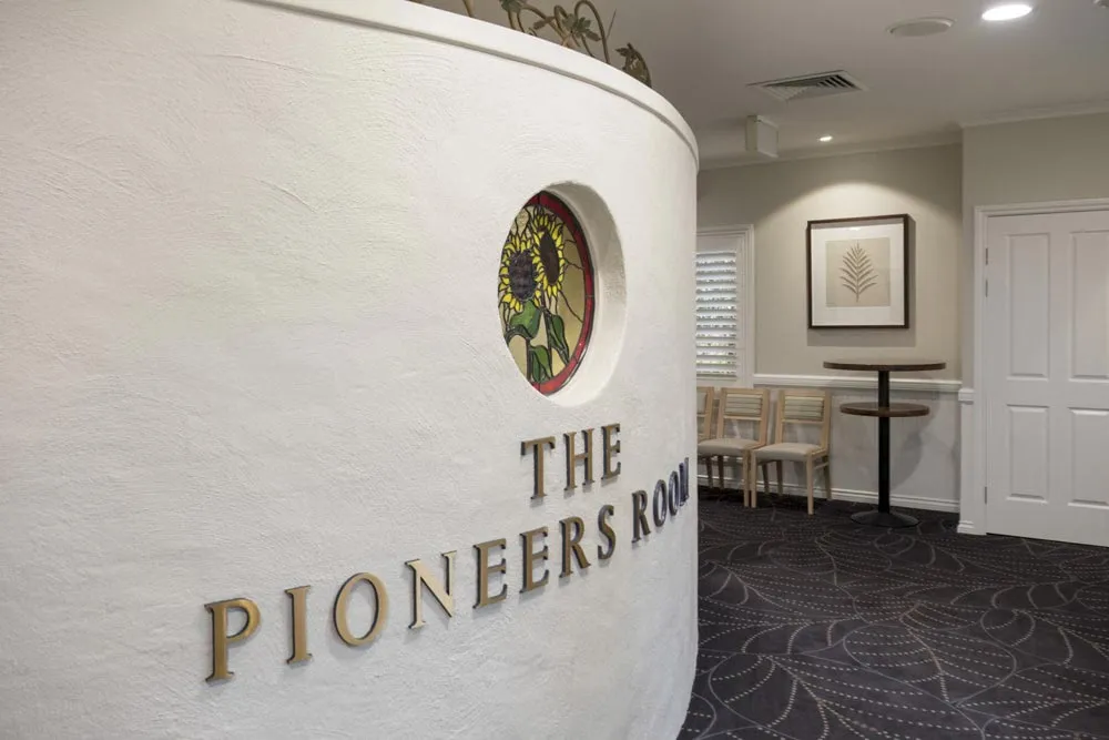 Close-up of "The Pioneer Room" sign on a wall.