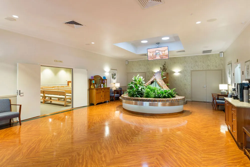 Chapel foyer with plant feature, seating, and screen.
