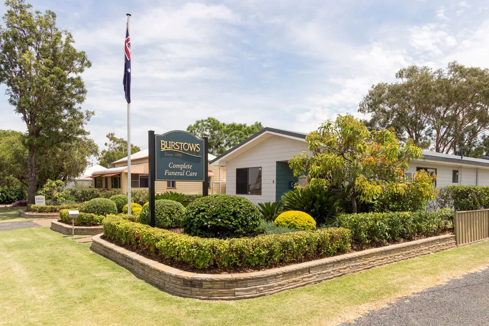 Well-maintained building exterior with garden and flagpole.
