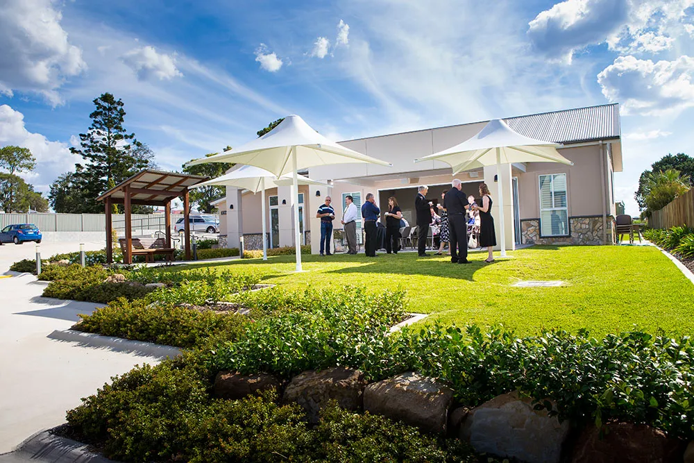 Modern building exterior with green landscaping and path.