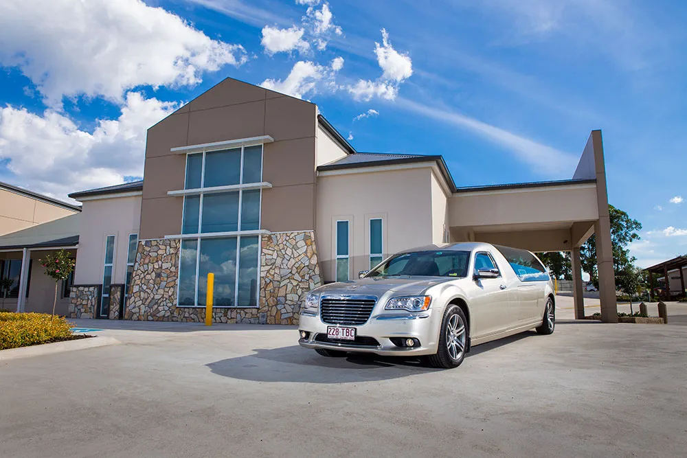 Modern building exterior with a white car in front.
