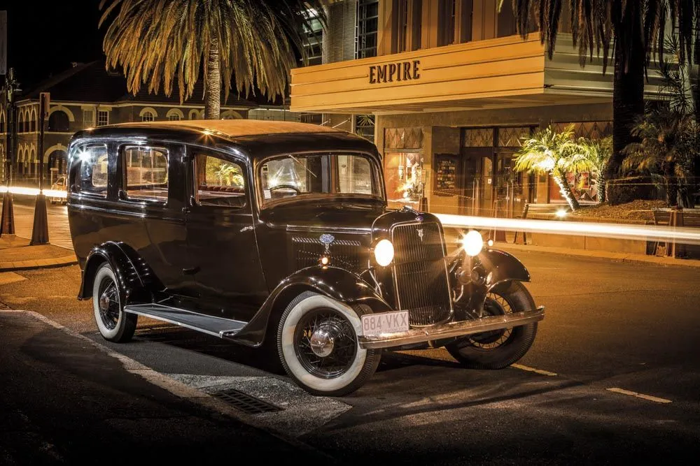 Vintage hearse parked outside a building at night.